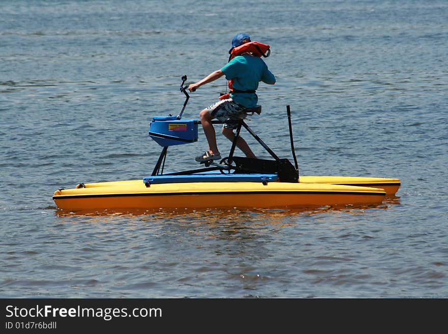 a young white caucasian boy on a paddle boat enjoying his summer vacation