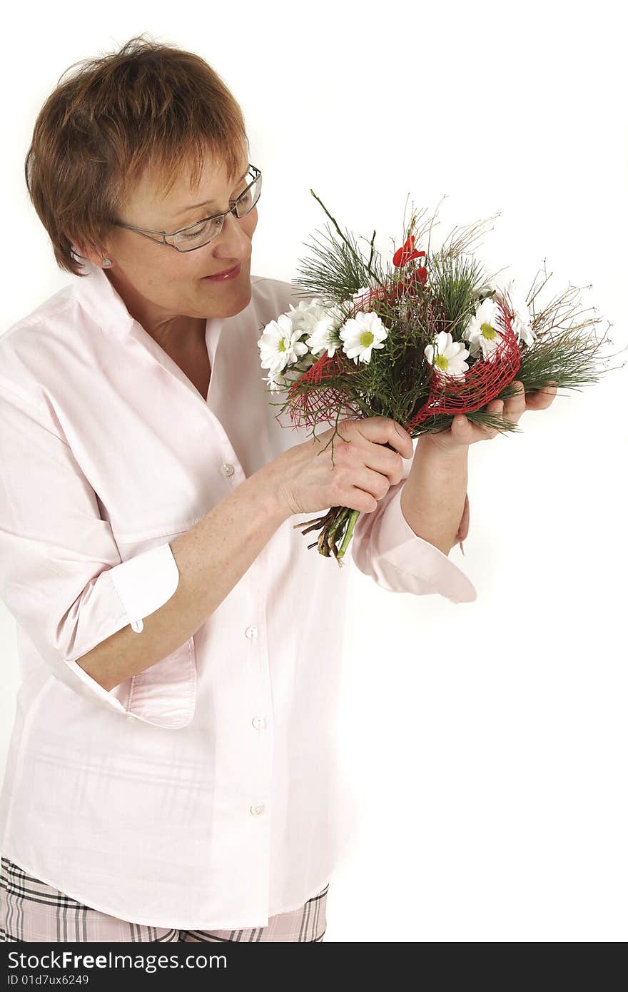 Elderly woman is smelling to flowers