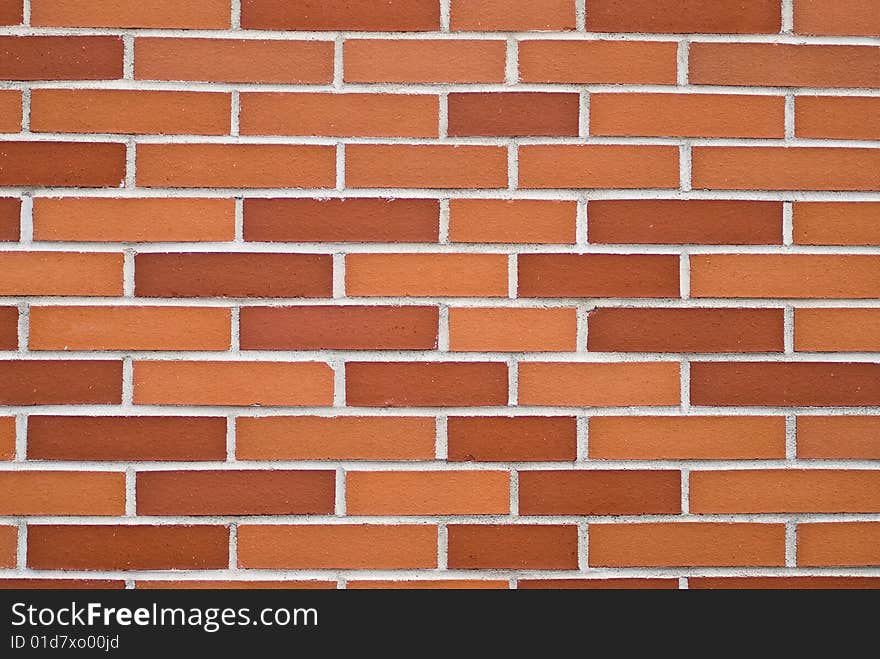 A brickwall with stones in shades of red and orange