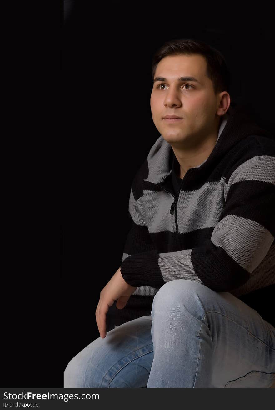 Young man thinking on a black background