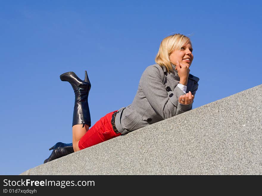 Young beautiful girl lying againt blue sky. Young beautiful girl lying againt blue sky