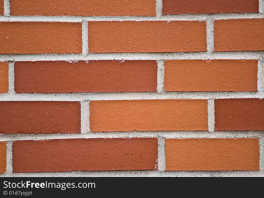 A brickwall with stones in shades of red and orange