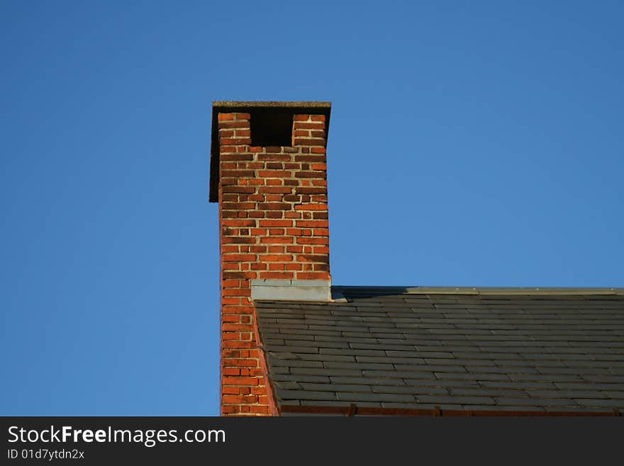 Chimney at a roof top and a blue sky background