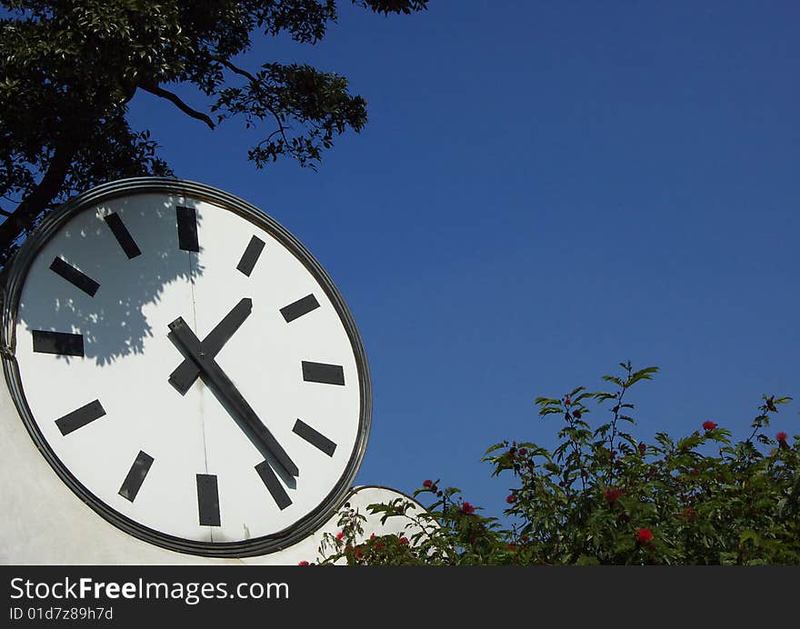 A clock in blue sky background