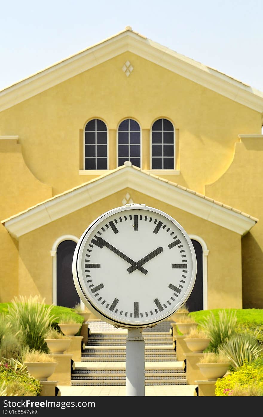 A big clock in front of a very nice house. A big clock in front of a very nice house...