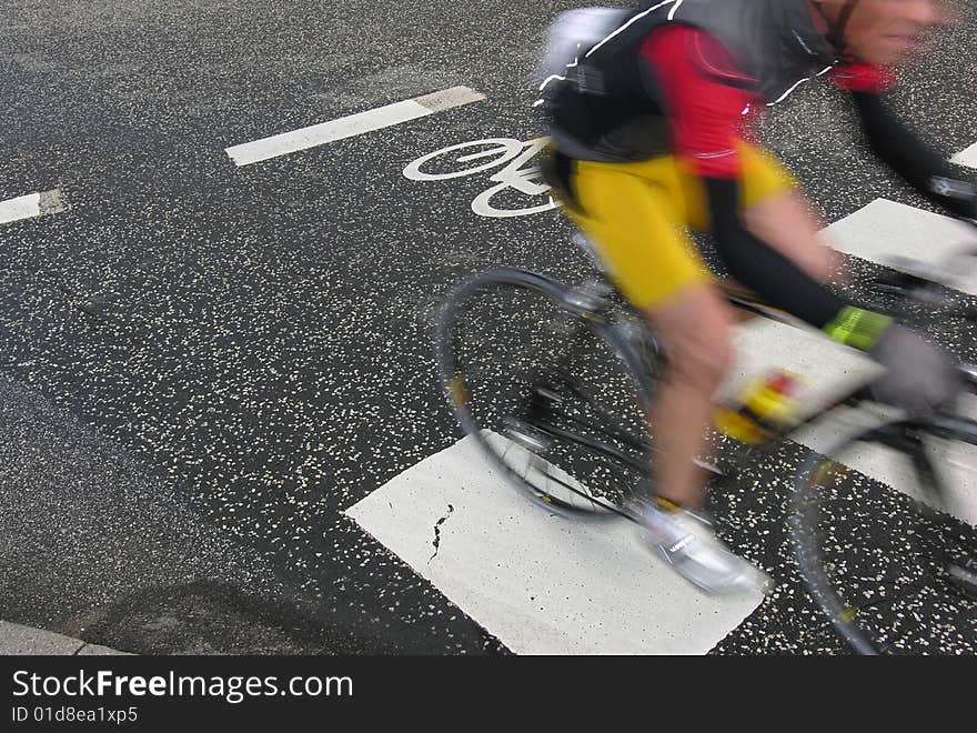 Cyclist race. Bike race in Denmark. Cyclist are passing a bike sign on the road. Speedy motion blur.