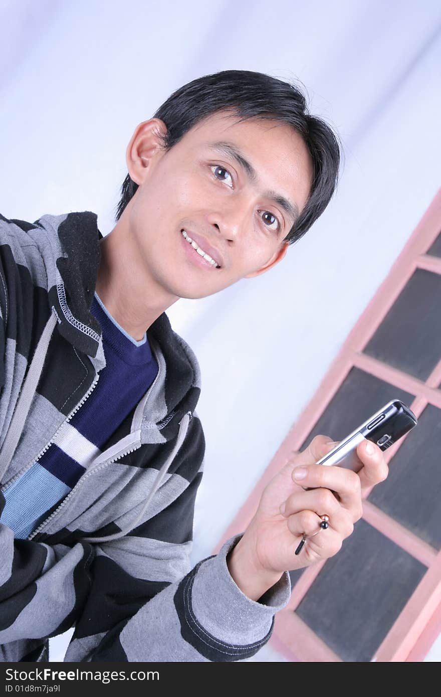 Man holding cellular phone smiling at home. Man holding cellular phone smiling at home