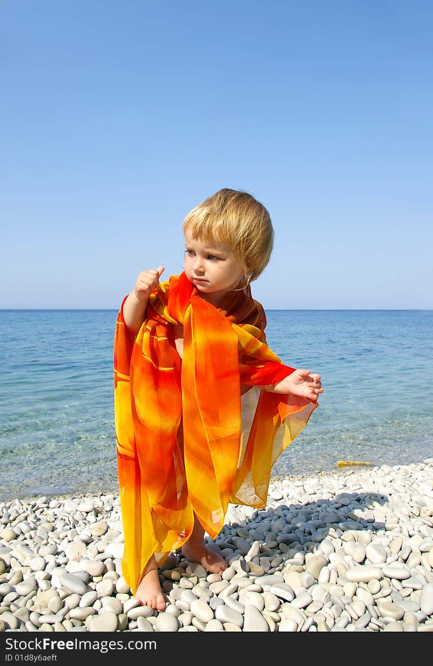 Cute little girl on seacoast. Pebbles beach. Cute little girl on seacoast. Pebbles beach