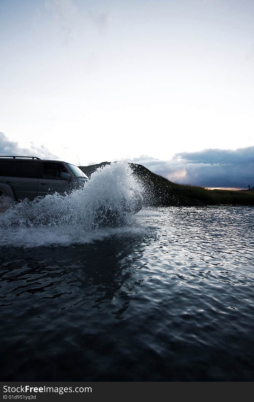 4x4 crossing the river at dusk