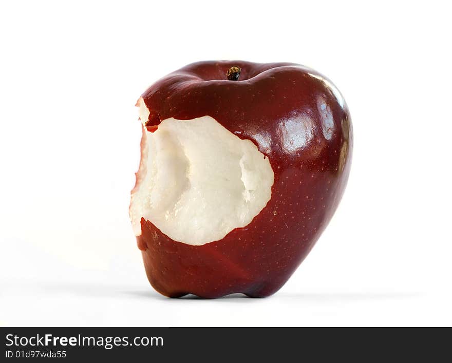 An isolated red delicious apple with two bites taken out of it.