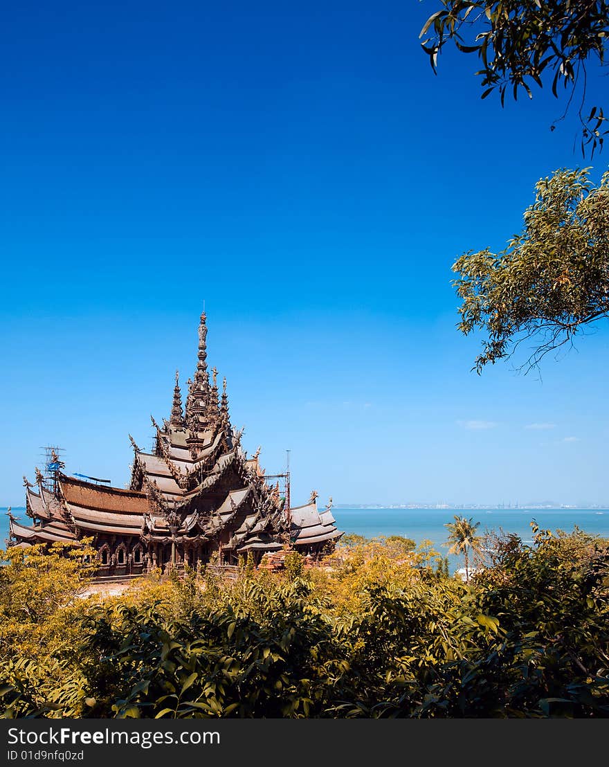 In Thailand in the city of Pattaya the sanctuary of truth is a wooden construction high of 105 meter covered with wooden carved sculpture; view of the sculpted roof. In Thailand in the city of Pattaya the sanctuary of truth is a wooden construction high of 105 meter covered with wooden carved sculpture; view of the sculpted roof