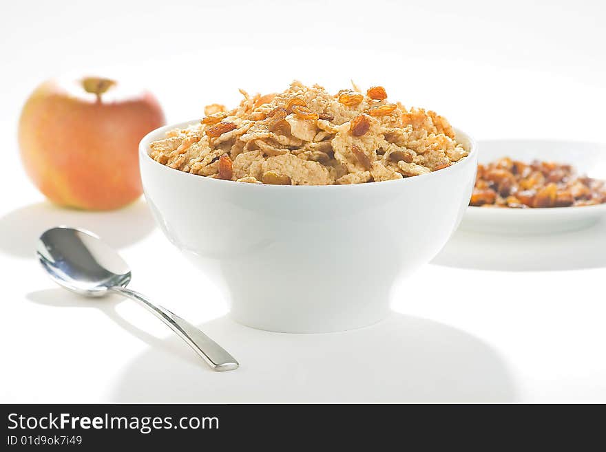 Bowl of cereal with raisins, milk and orange juice