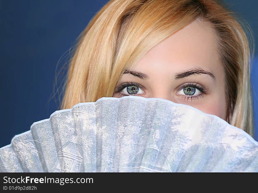 Beautiful blonde with gorgeous eyes holding fan. Beautiful blonde with gorgeous eyes holding fan