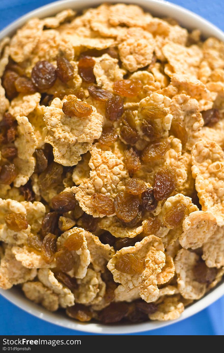 Bowl of cereal with raisins, milk and orange juice