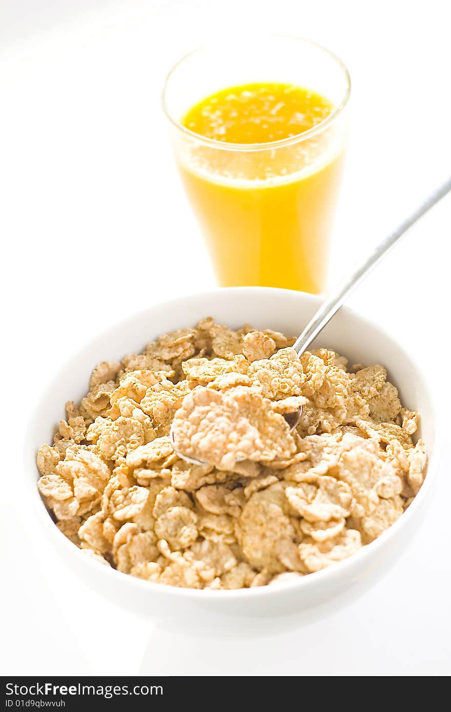 Bowl of cereal with raisins, milk and orange juice