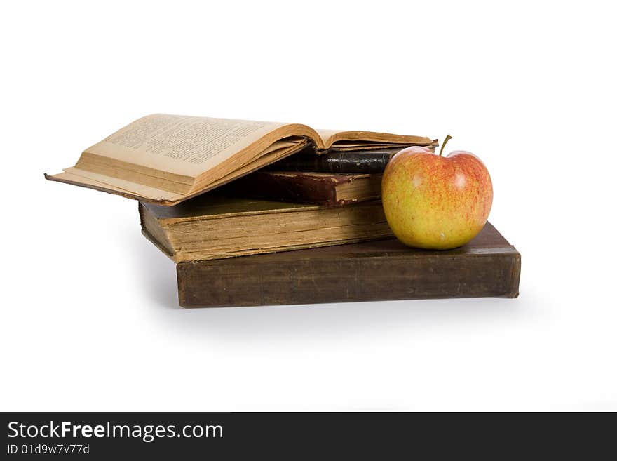 Apple on pile of old books isolated on white
