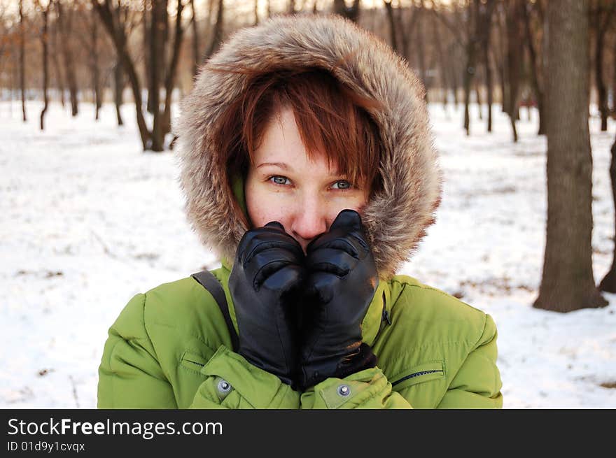 Portrait of young frozen woman in green jacket