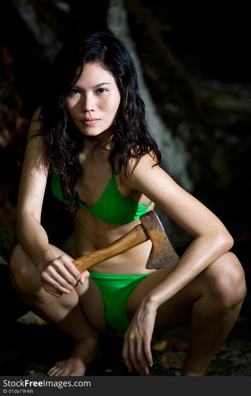 Wild Outdoor asian woman holding an axe. Wild Outdoor asian woman holding an axe