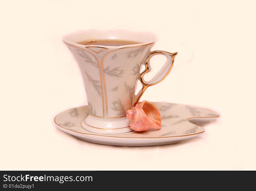 Cup with tea and pink Cockleshell. Cup with tea and pink Cockleshell