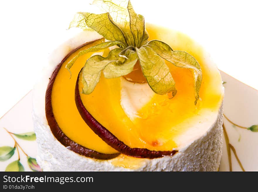 Decoration on a piece of cake from fruits and leaflets. Cake of the whipped cream and fruits isolated on white background. Decoration on a piece of cake from fruits and leaflets. Cake of the whipped cream and fruits isolated on white background.