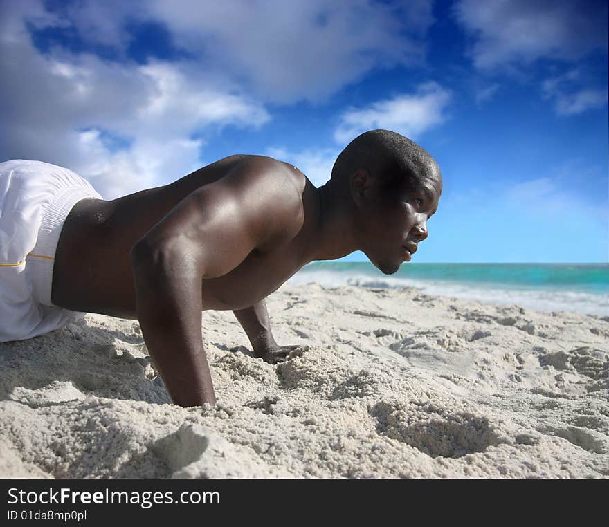 Black man doing flexions on the beach