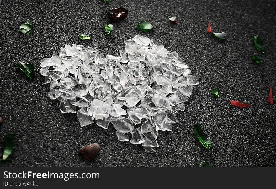 Heart shape made from white glass pieces on gray surface. Heart shape made from white glass pieces on gray surface