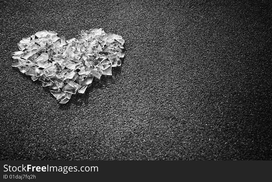 Heart shape made from white glass pieces on gray surface. Heart shape made from white glass pieces on gray surface