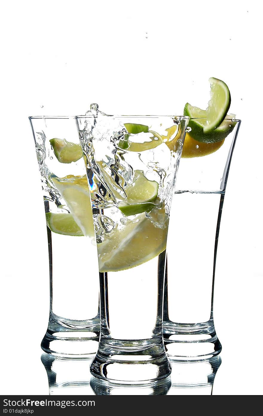 Glasses with water and lime on the white background