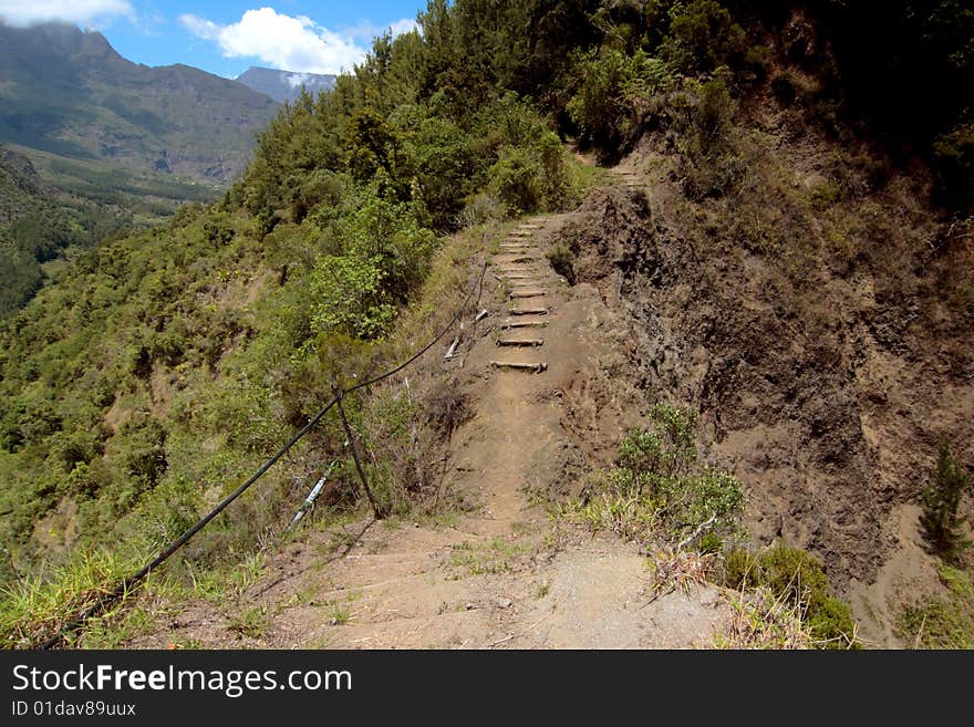 Hiking trail surrounded by precipices, inside Mafate caldera, Reunion island