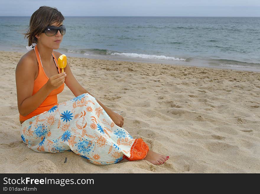 Beautiful girl eating icecream in the beach. Beautiful girl eating icecream in the beach