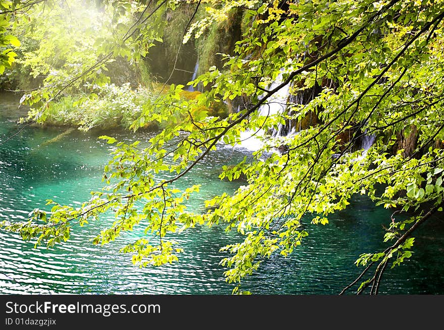 Pictorial scene of emerald lake and waterfall