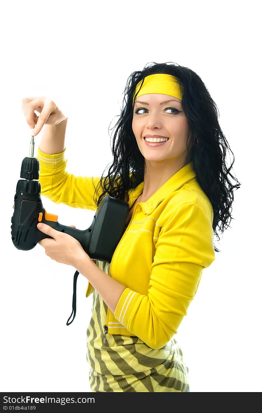 Cheerful young brunette woman holding a drill in her hands isolated against white background. Cheerful young brunette woman holding a drill in her hands isolated against white background