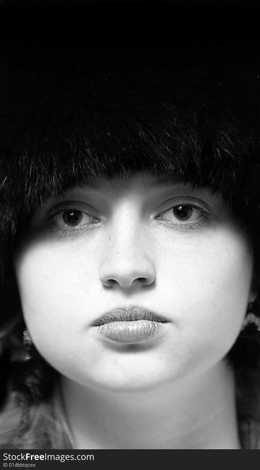 Black-n-white woman portrait in black fur-cap looking to camera