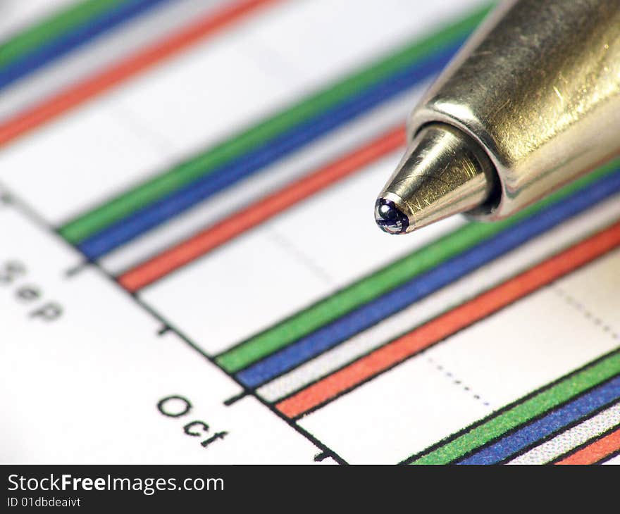 A pen against statistic chart. A pen against statistic chart.