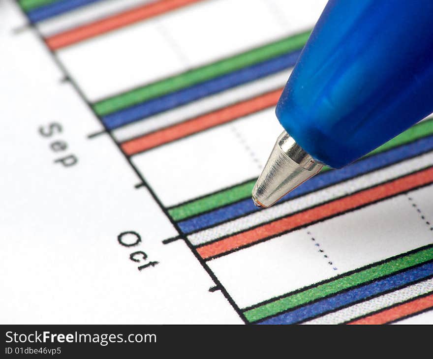 A pen against statistic chart. A pen against statistic chart.