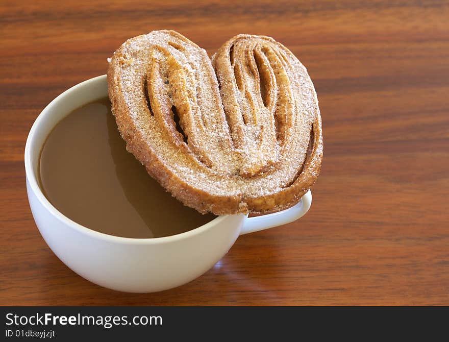 Cup of hot coffee and palmier cookie