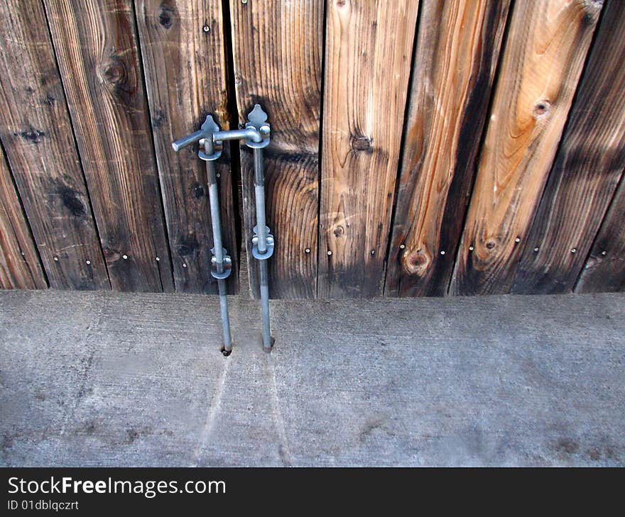 Looking down at a wooden gate with a metal closure. Looking down at a wooden gate with a metal closure.