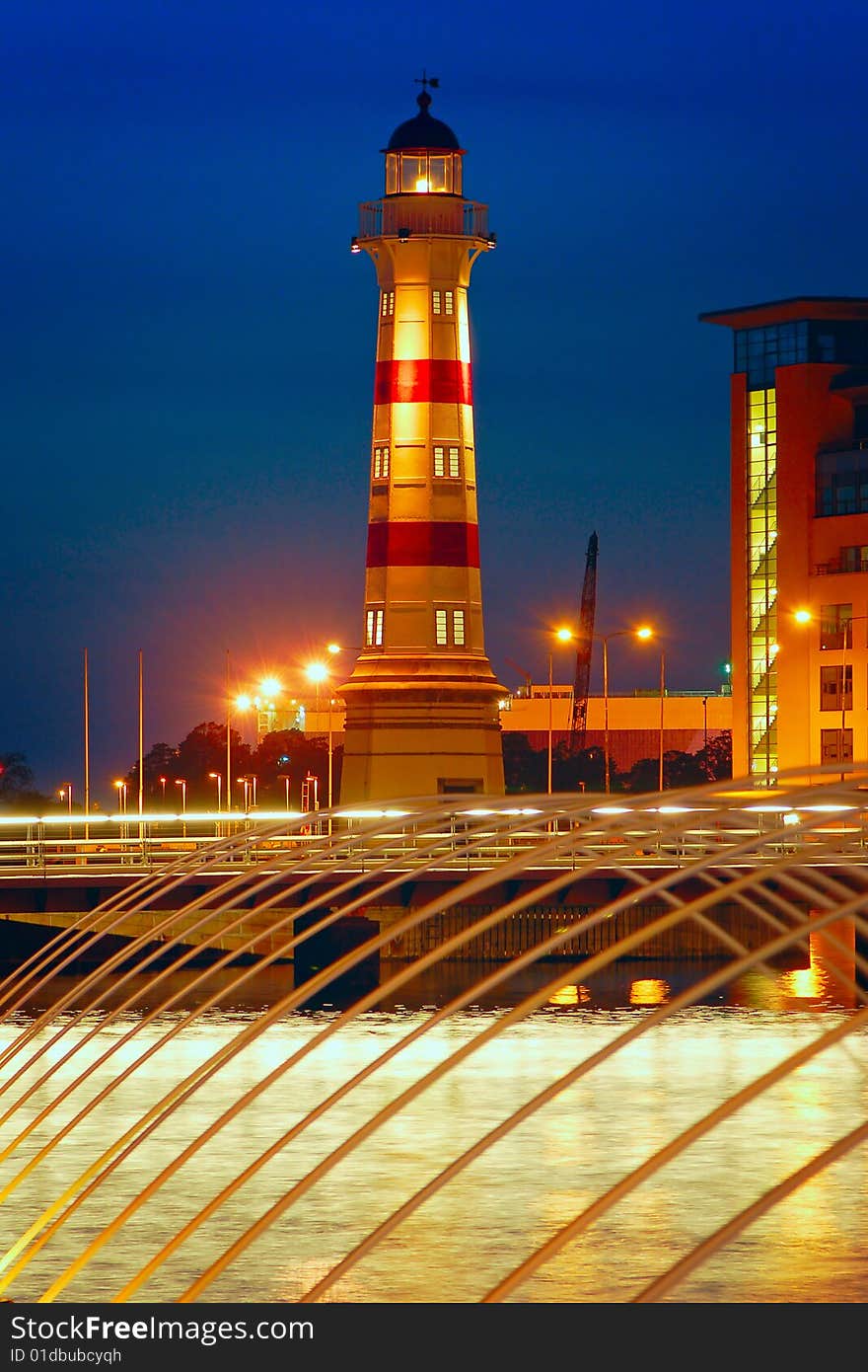 A light house in a city with a fountain in the foreground. A light house in a city with a fountain in the foreground