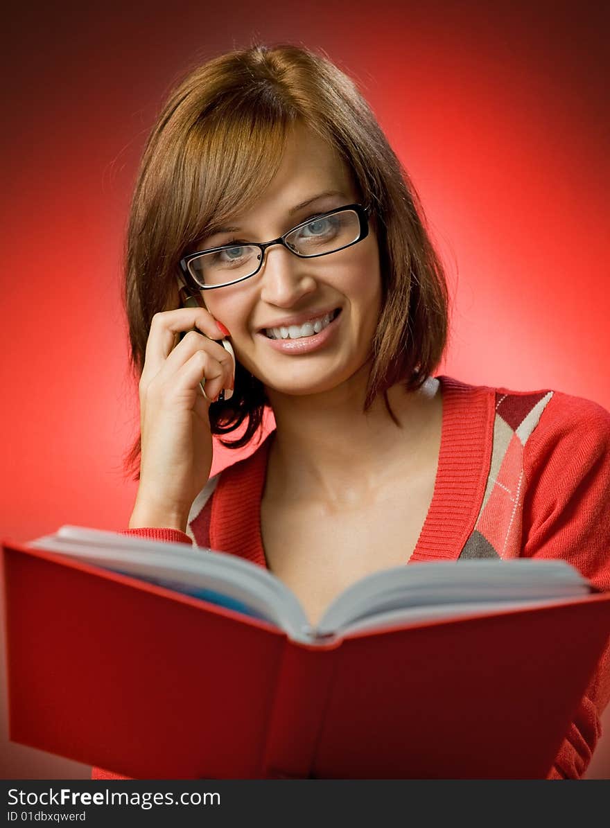 Beautiful redhead woman searching a phone number in telephone directory