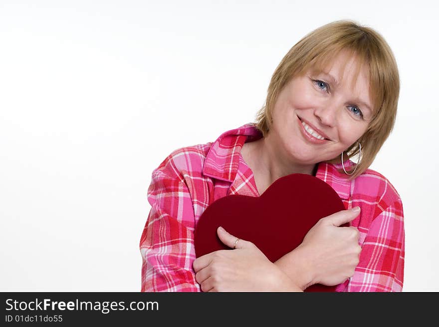 An attractive woman hugs the box of valentines day chocolates she just received as a gift. She is expression happiness. An attractive woman hugs the box of valentines day chocolates she just received as a gift. She is expression happiness.