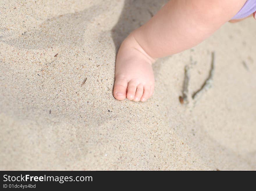 Children's foot on sea sand