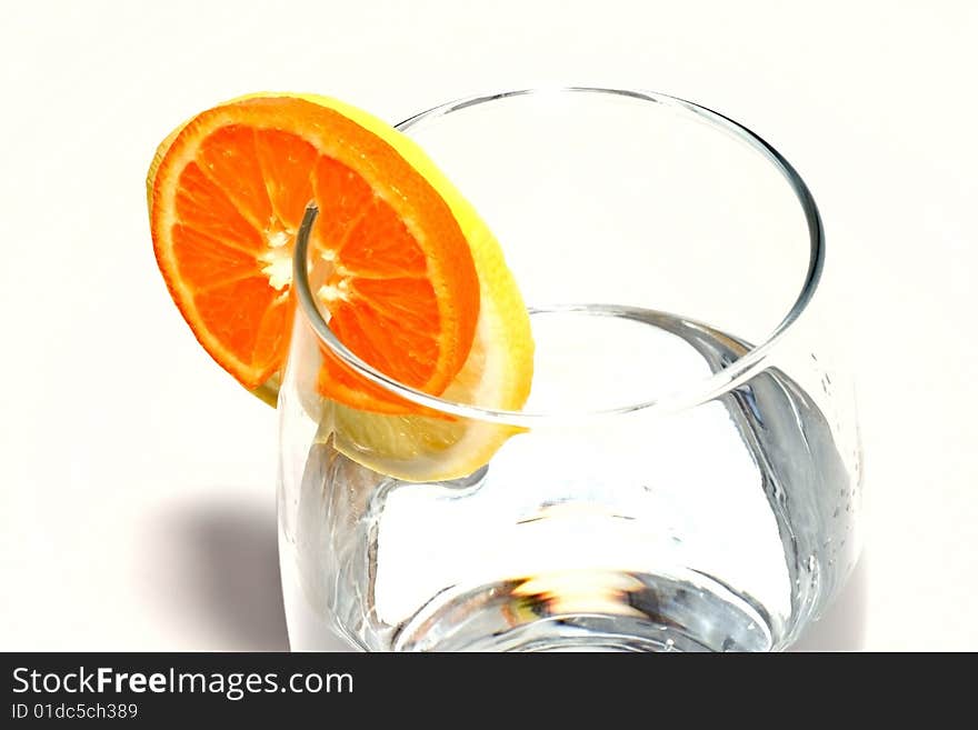 Fresh water with glass, lemon and orange decorated with a circle. Isolated on white background. Fresh water with glass, lemon and orange decorated with a circle. Isolated on white background.