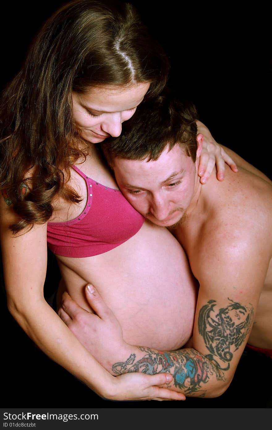 Couple in love expecting a baby. Husband is embracing her belly. Couple in love expecting a baby. Husband is embracing her belly.