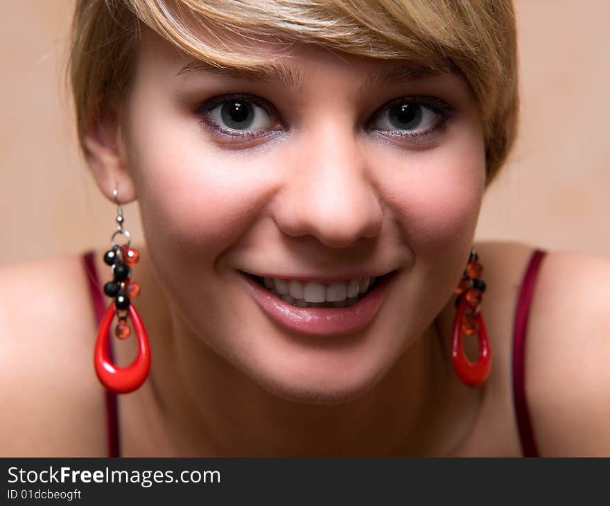 Pretty girl with red pendants - close-up face portrait