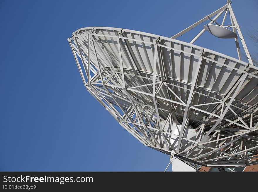 A large satellite dish by parabolic antenna on blue sky