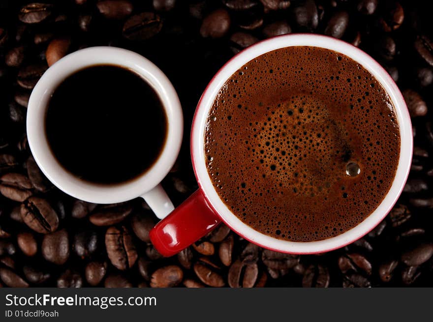 A cup of black coffee and coffee beans