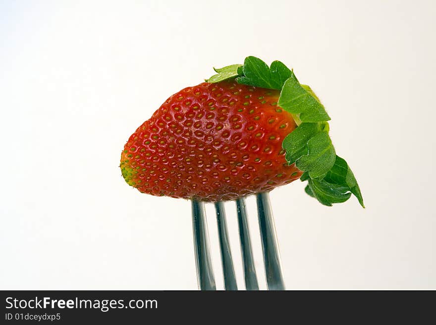 Strawberry on a fork waiting to be eaten