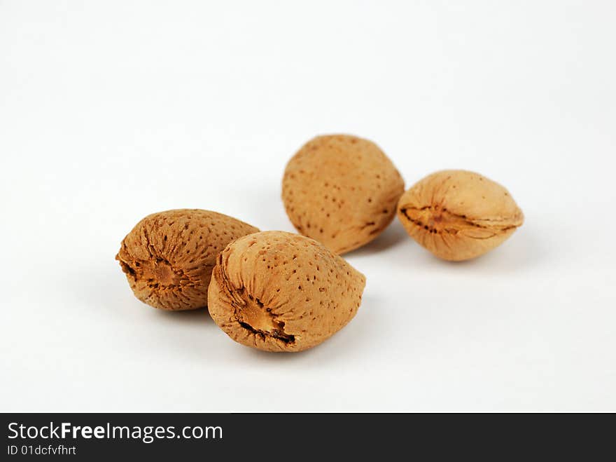 Four almond nuts on a white background. Four almond nuts on a white background