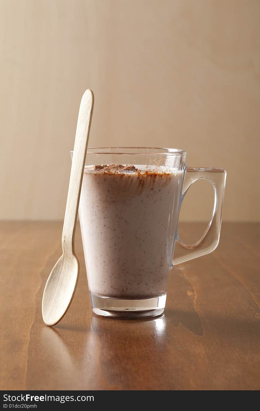 Glass of fresh drinking chocolate with wooden spoon