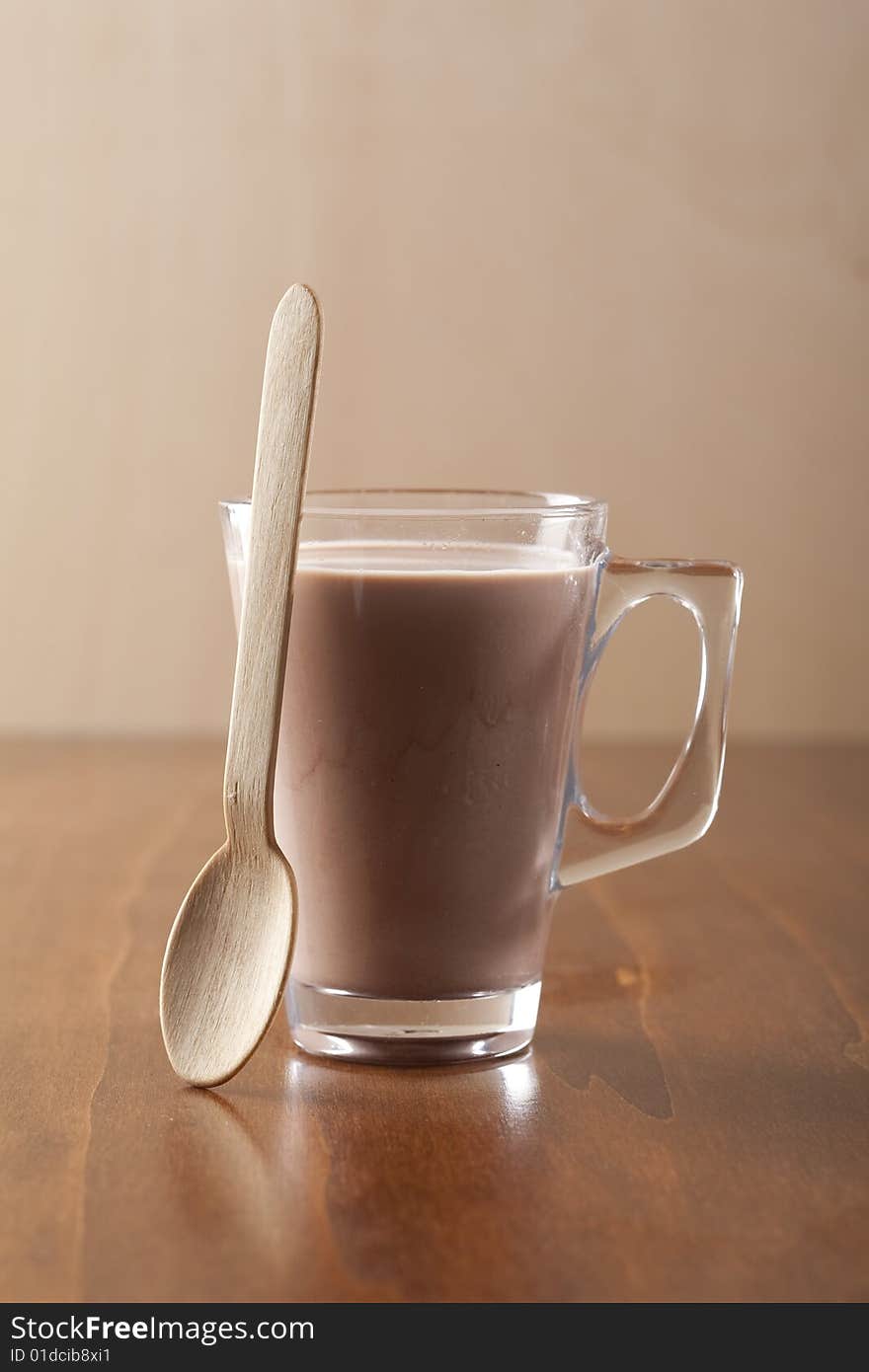 Glass of fresh drinking chocolate with wooden spoon